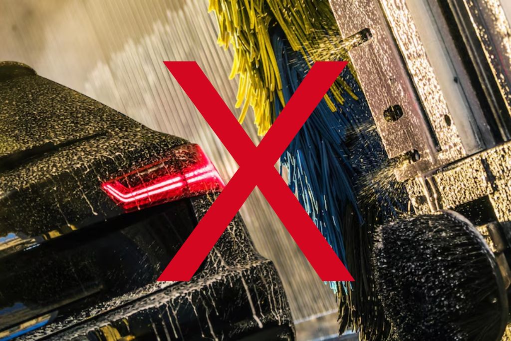 A red "X" overlays an image of a car going through an automatic car wash with spinning brushes and high-pressure water, highlighting the risk of damage to paint protection film from abrasive machinery.