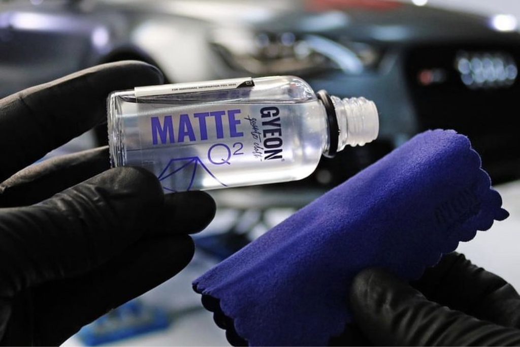 Gloved hands prepare to apply GYEON Q2 Matte ceramic coating using a microfiber applicator, demonstrating a high-quality process that supports the question—is ceramic coating worth it for protecting your car in varied climates?